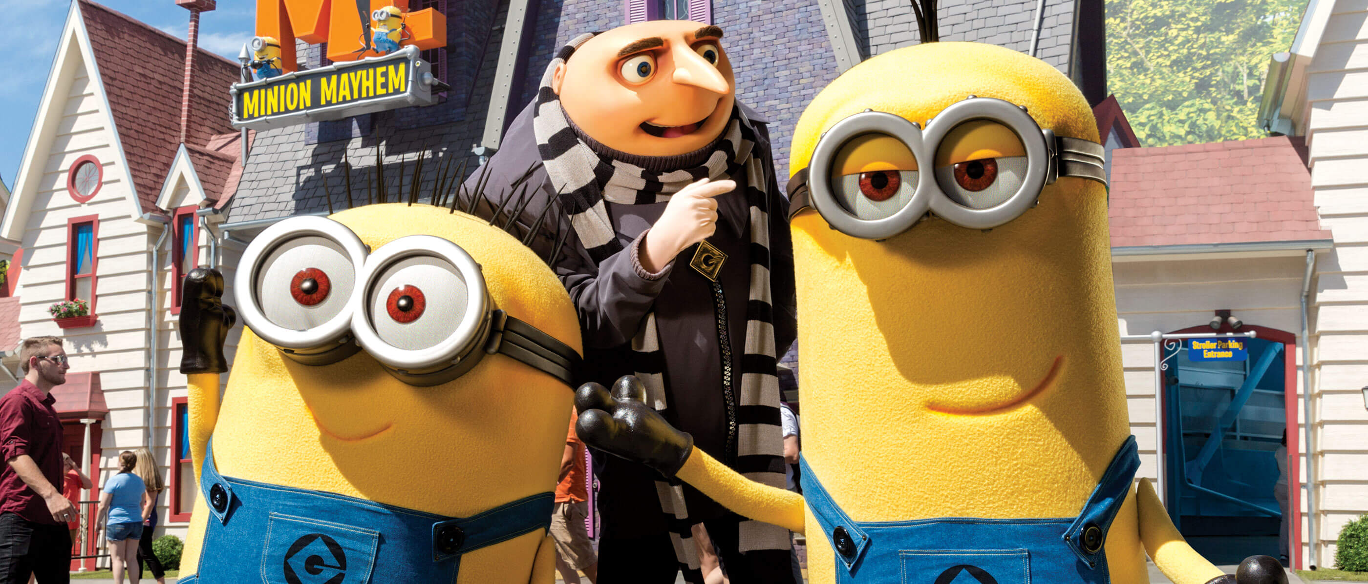Gru and two minions in front of Gru's house.