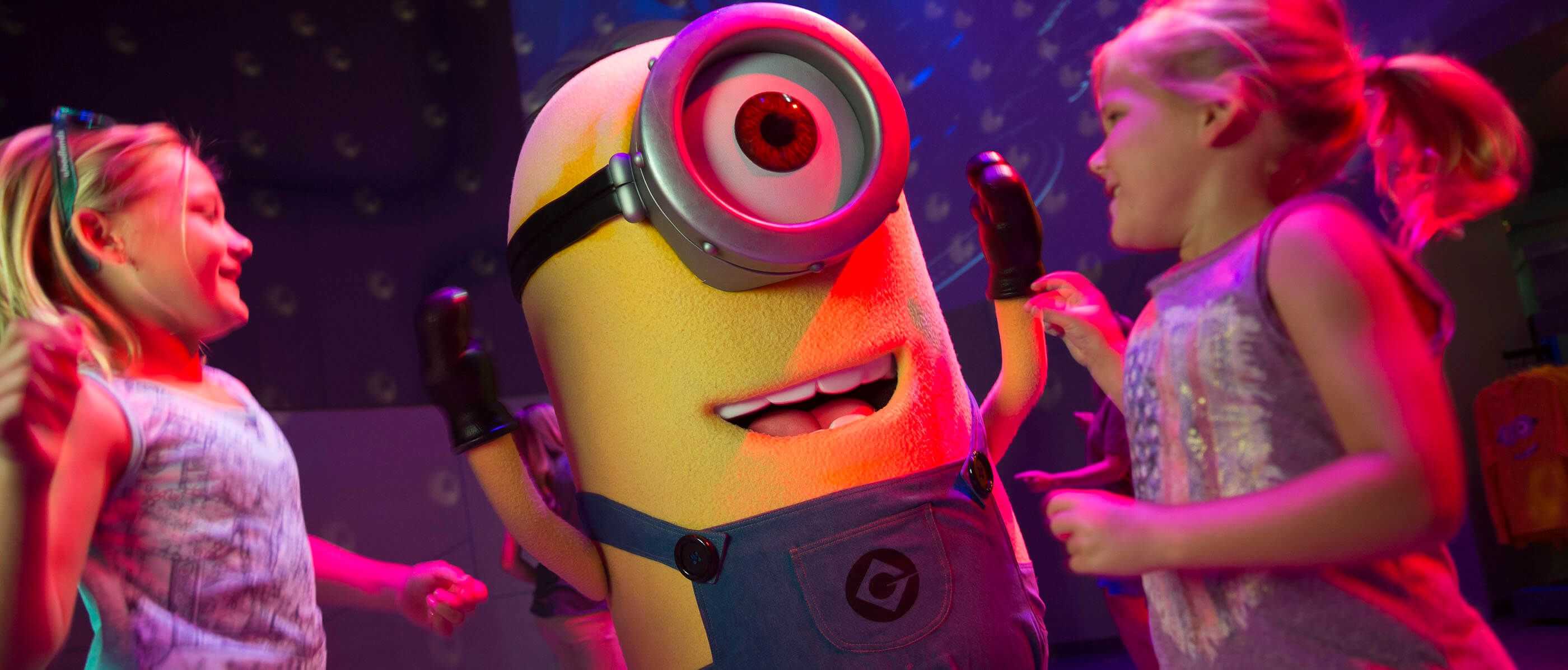 Two young girls dance and play with a Minion.