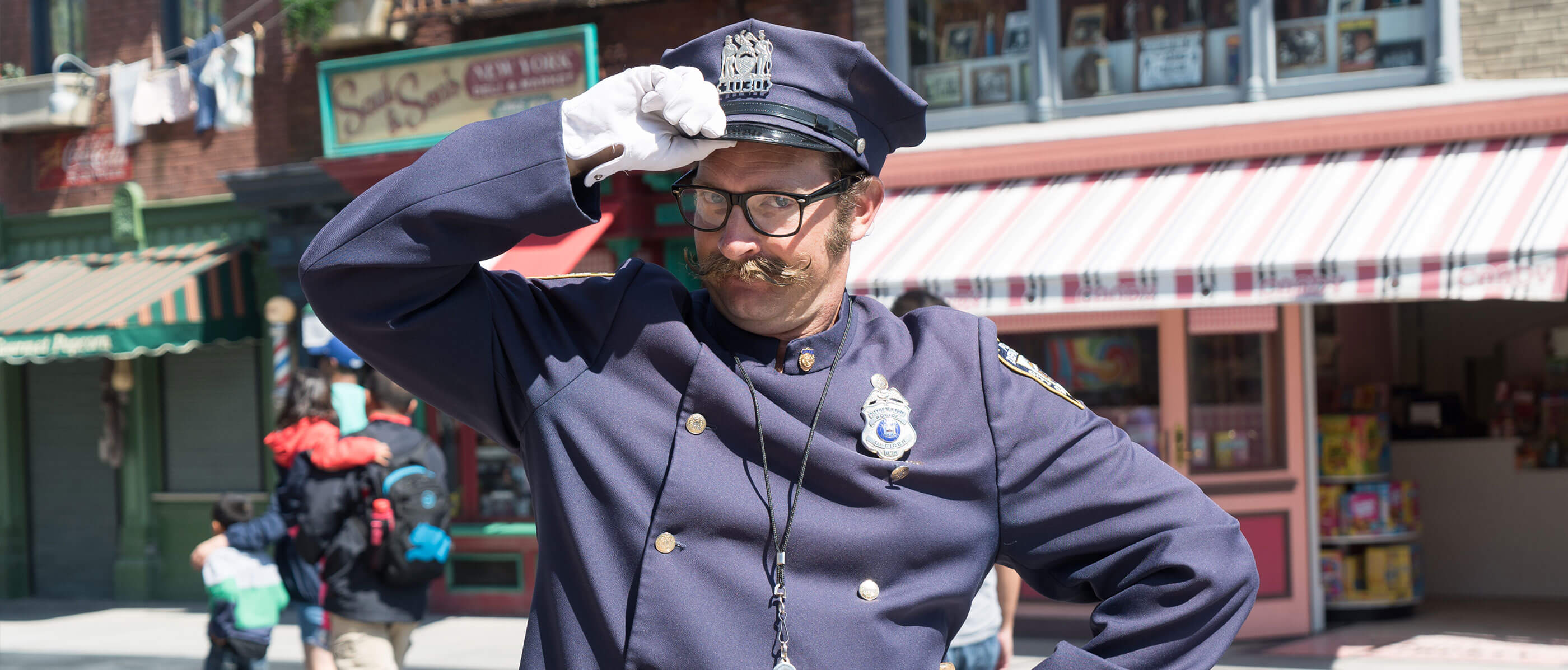 A police officer tipping his hat in front of a store.