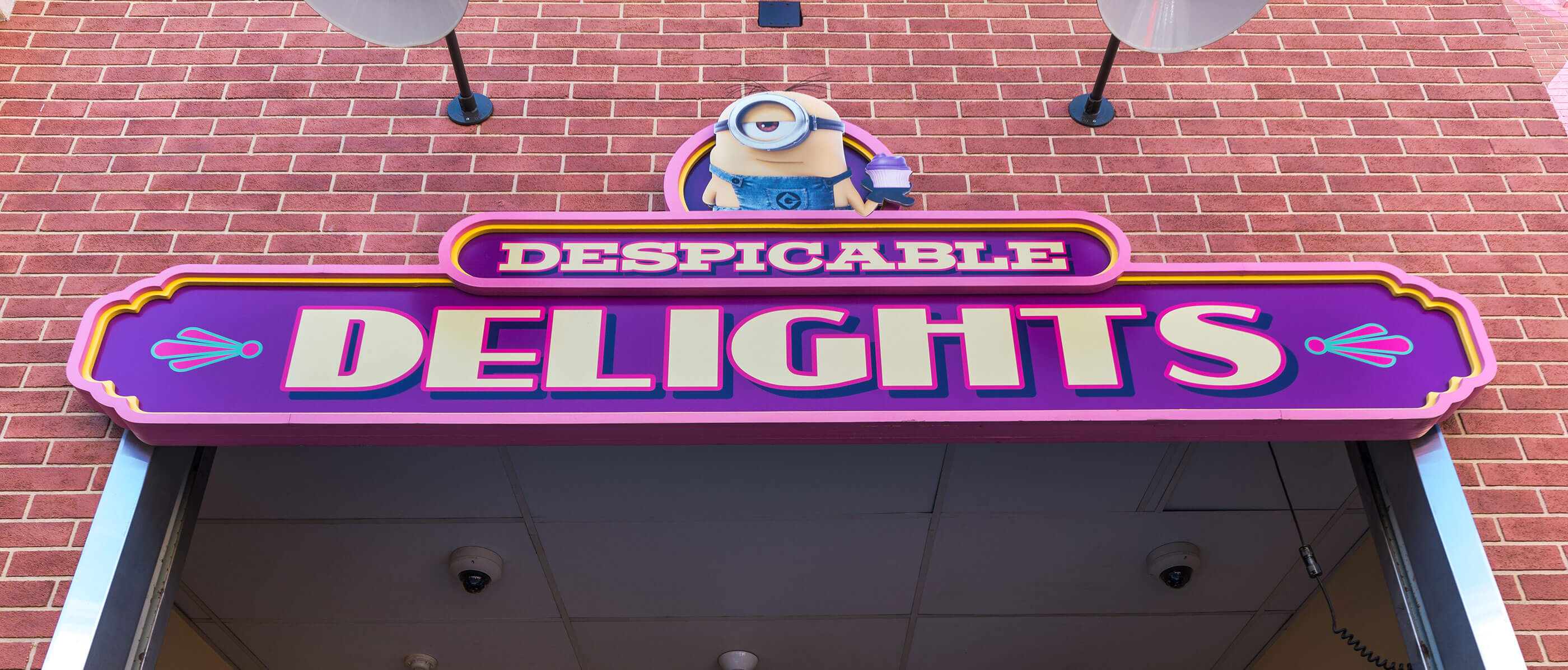 Despicables Delights sign and a brick wall behind.