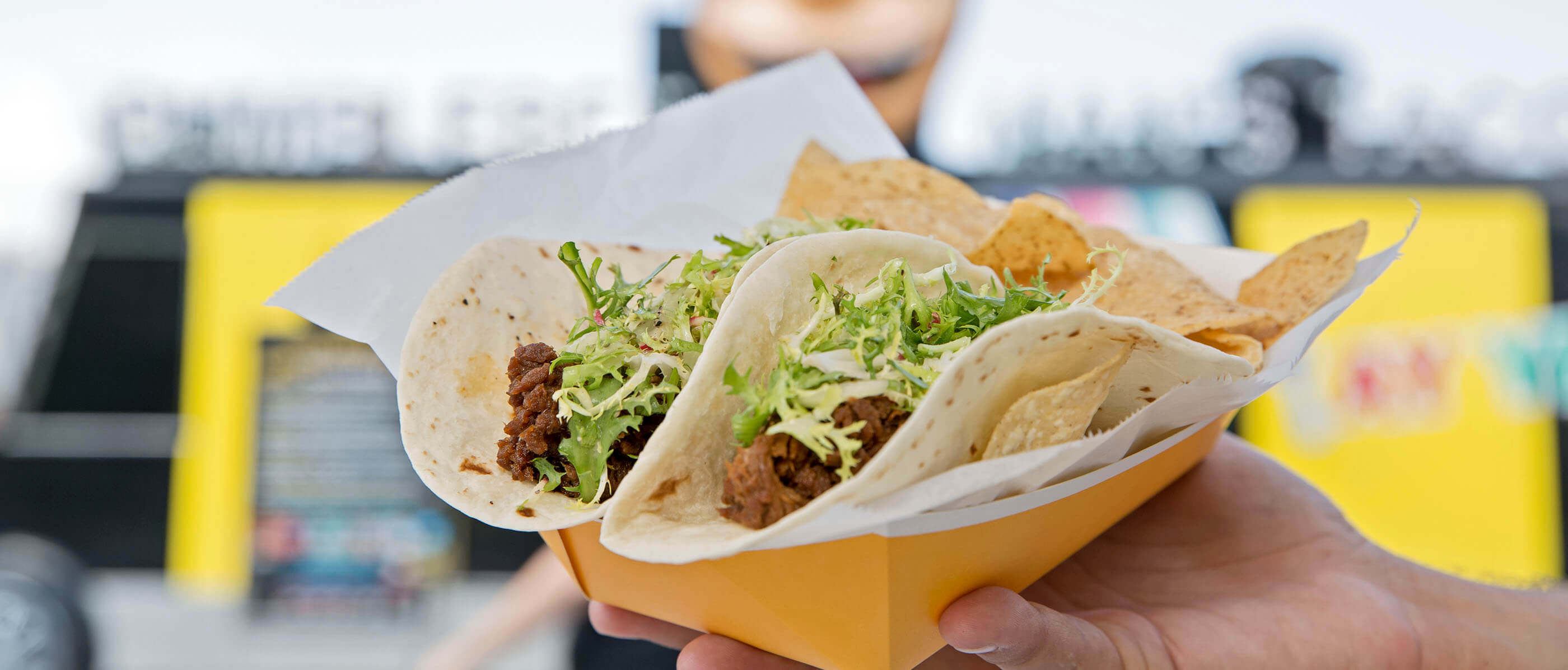 Two tacos with lettuce and meat on it.