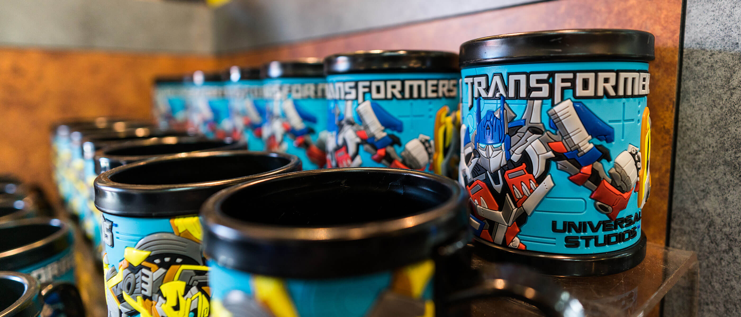 Rows of black mugs with Transformers on them.