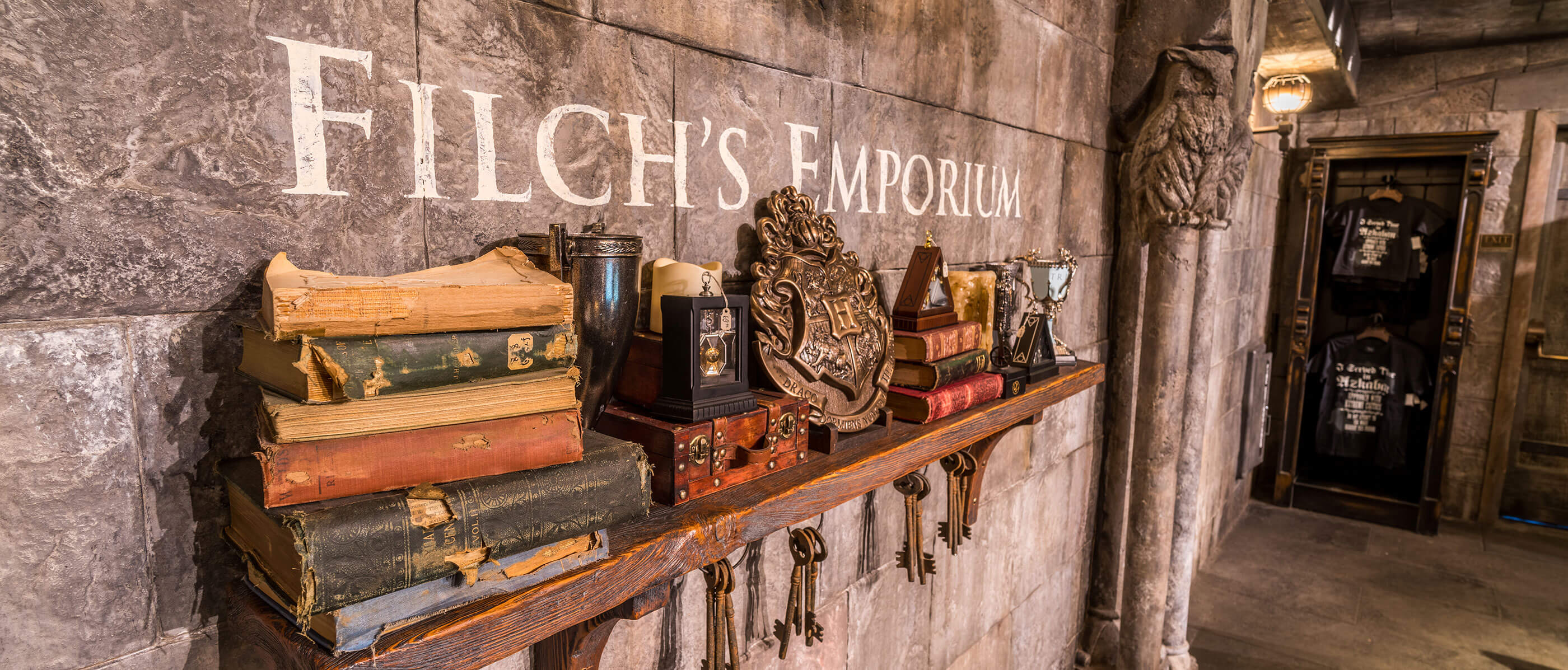 Wall with Filch's Emporium on it and a shelf with books.