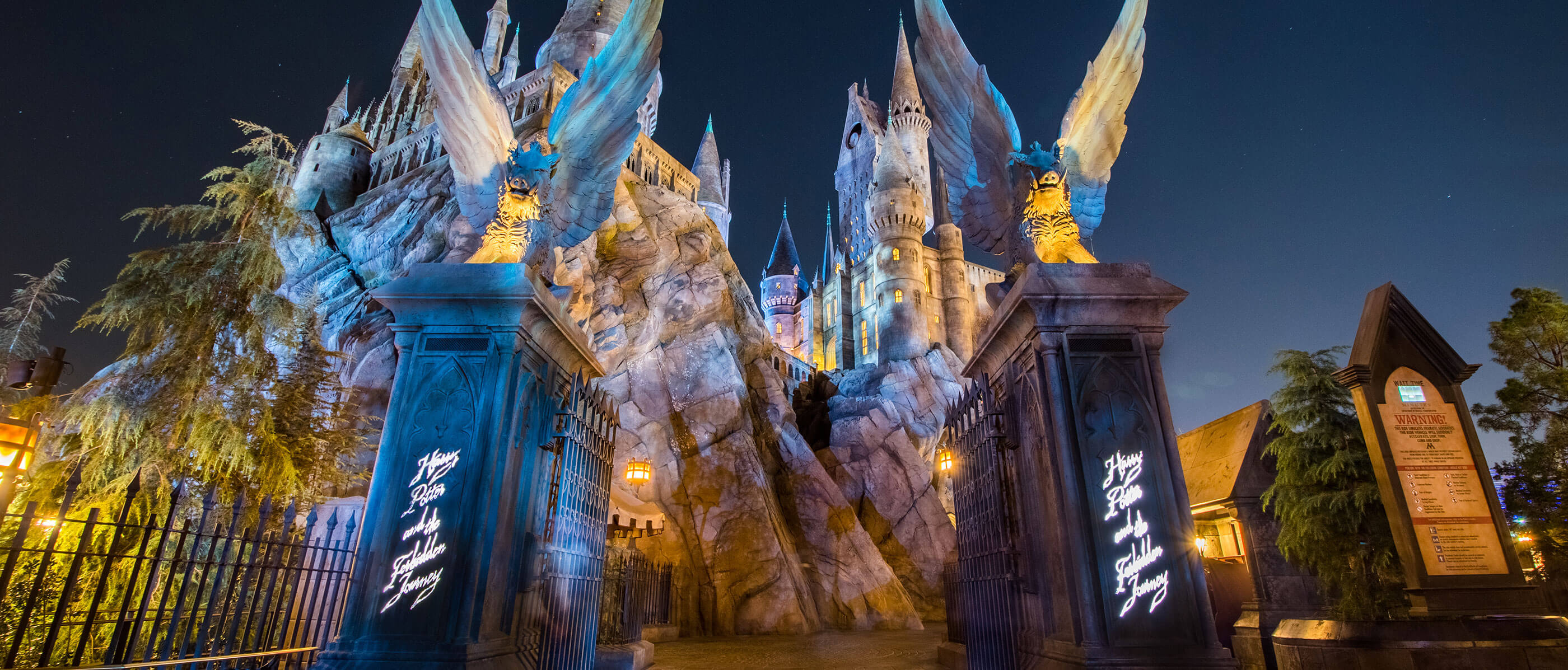 The ornate and imposing entrance to the Harry Potter Forbidden Journey ride at night.