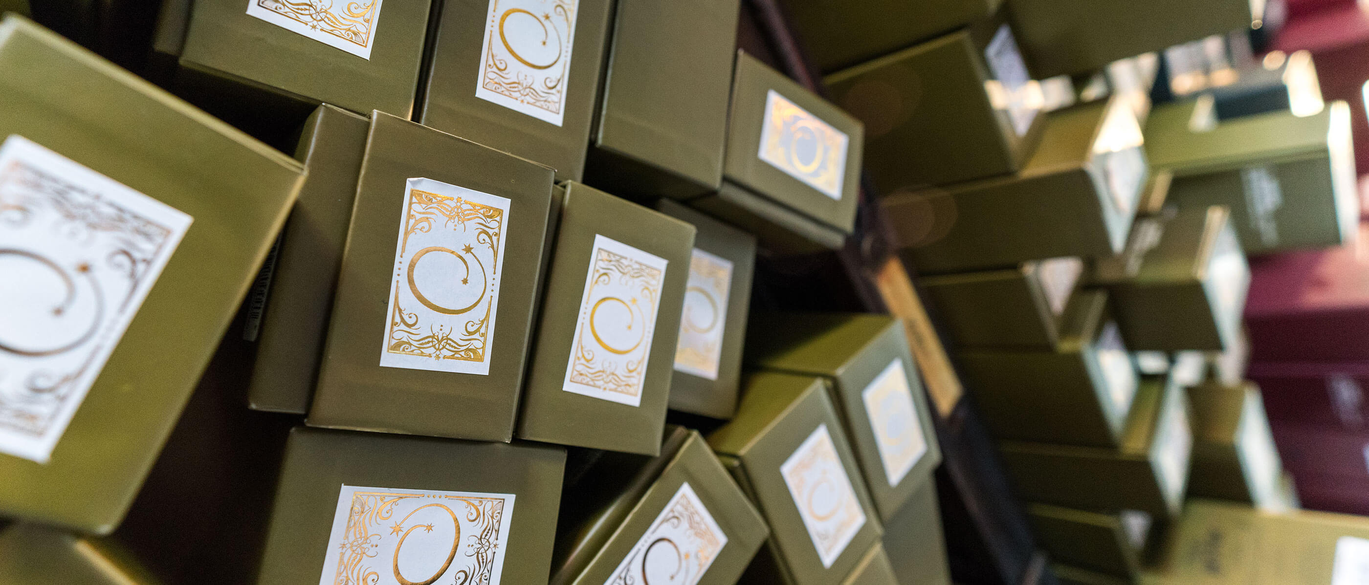 Ollivanders black wand boxes with a white and gold sticker.