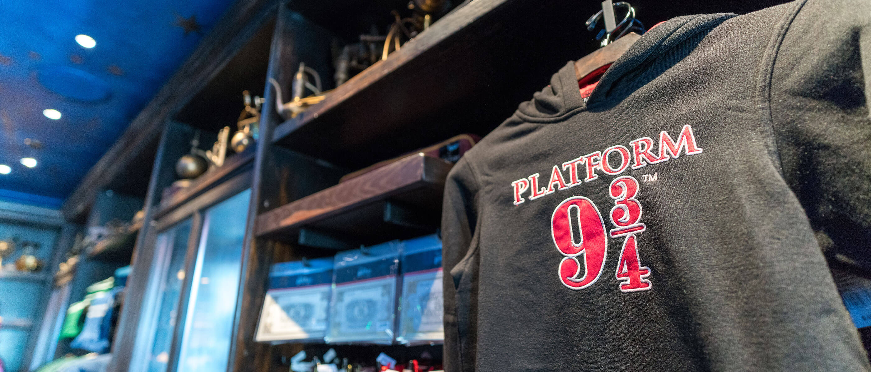 A wall with merchandise and a grey sweater with Platform 9 3/4 on it.