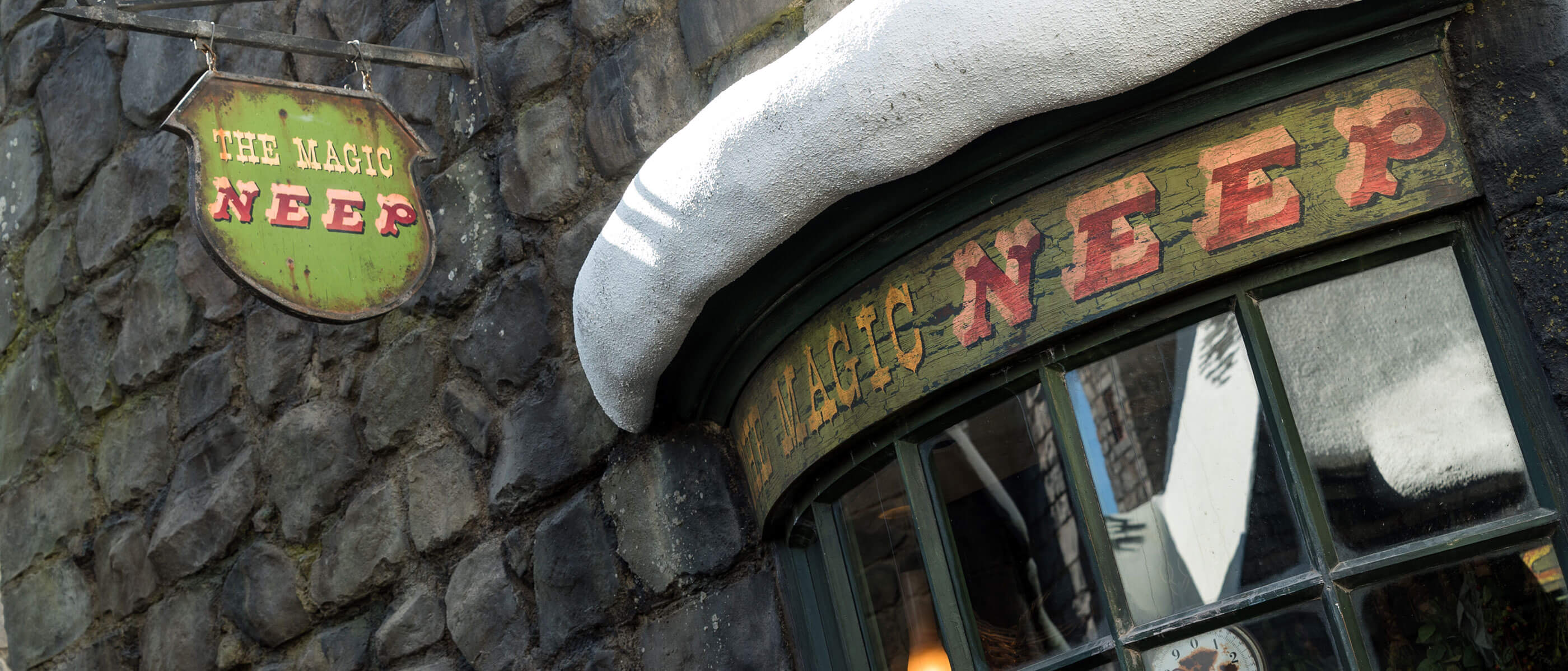 Harry Potter set of The Magic Neep sign with a stone wall behind it.