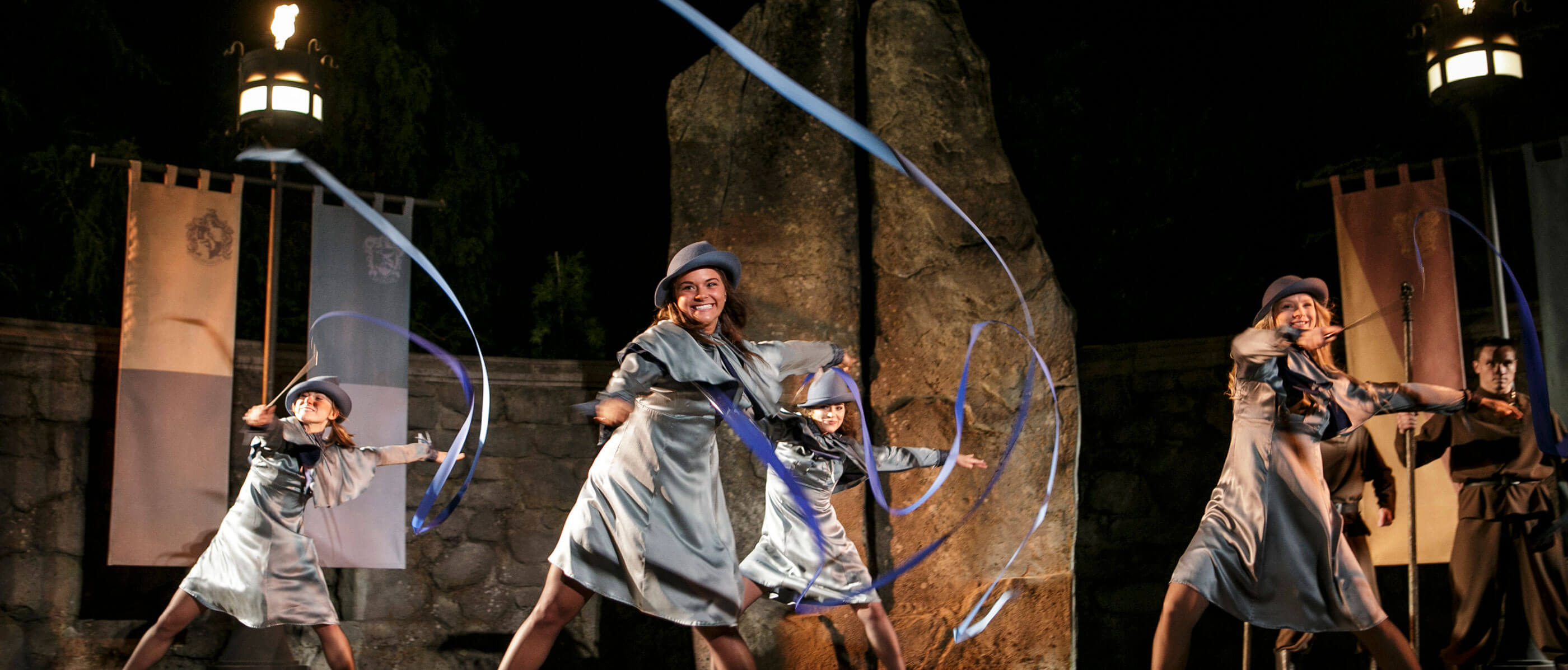 Four women dressed as Harry Potter characters, twirling ribbon.