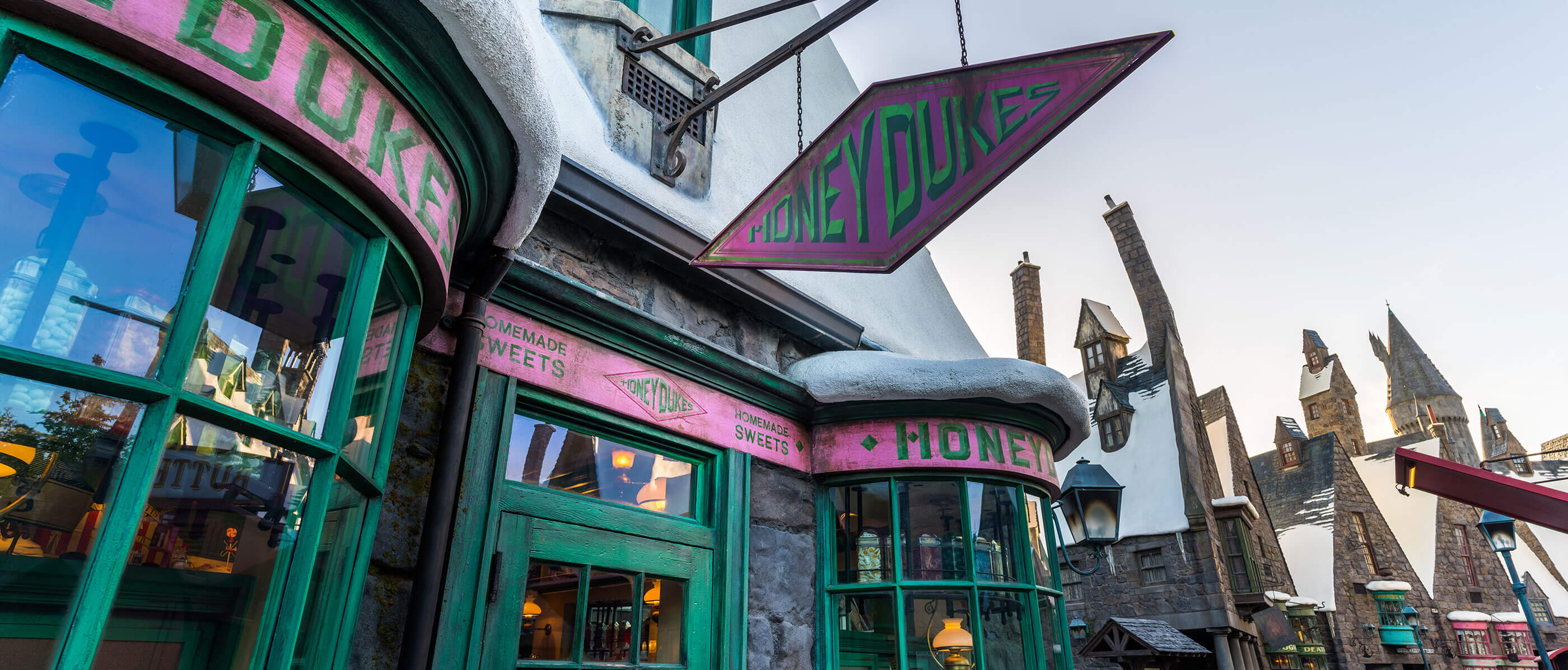 Outside of a Honeydukes store that's green and pink.