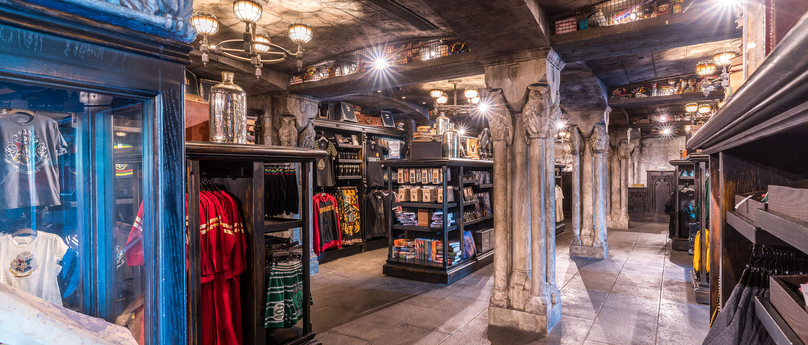 A store with stone pillars and black shelves full of clothes and product.