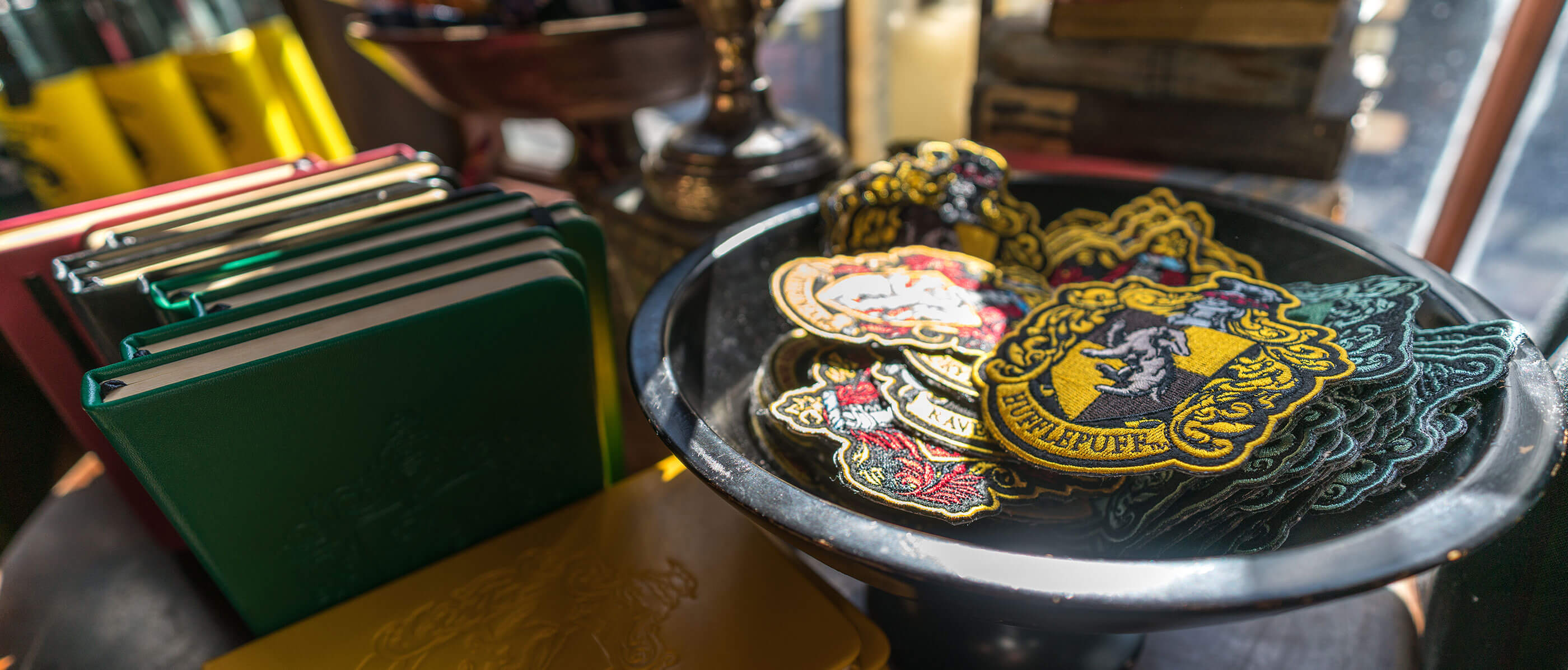 A bowl holding with the Hogwart houses symbols on them.
