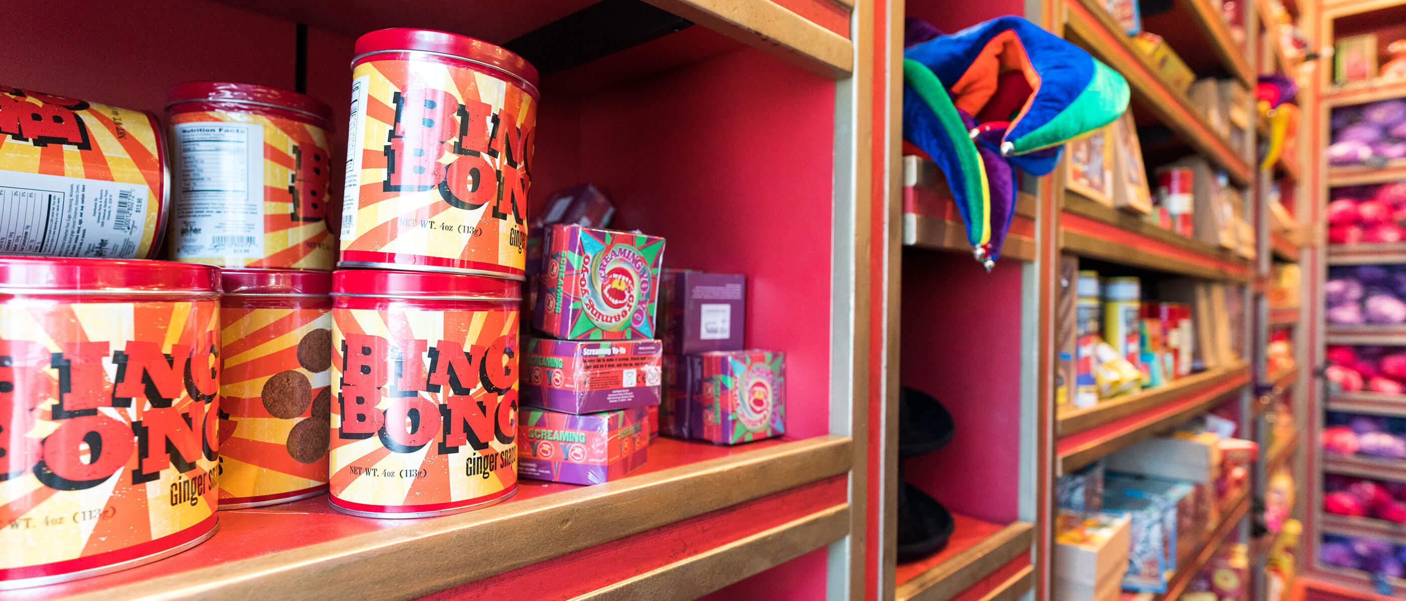 Red shelves with Ping Pong items on them.