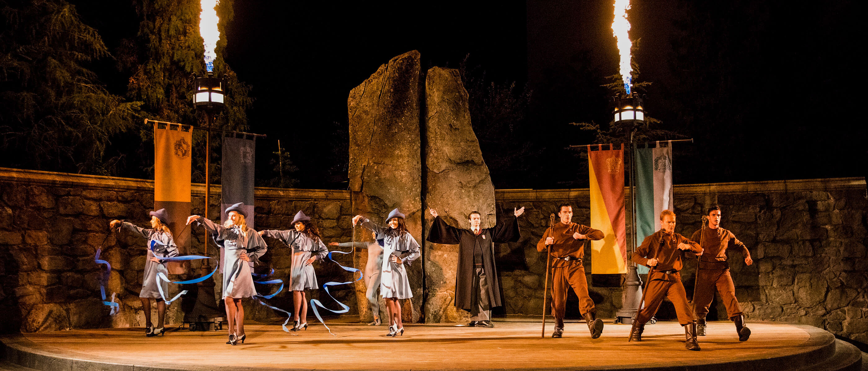 People performing on stage a scene from Harry Potter at night.