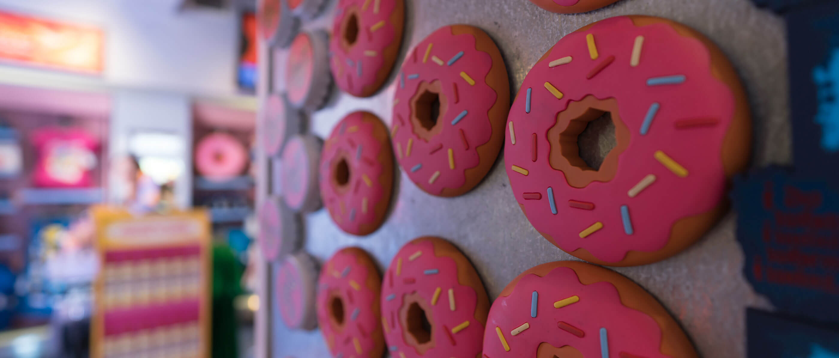 Donuts magnets with pink icing and sprinkles.