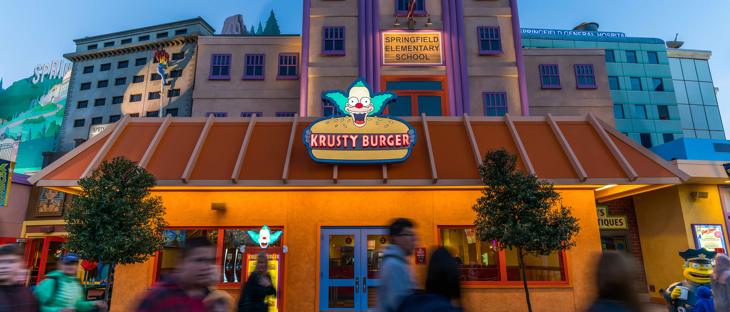People walking past Krusty Burger restaurant.