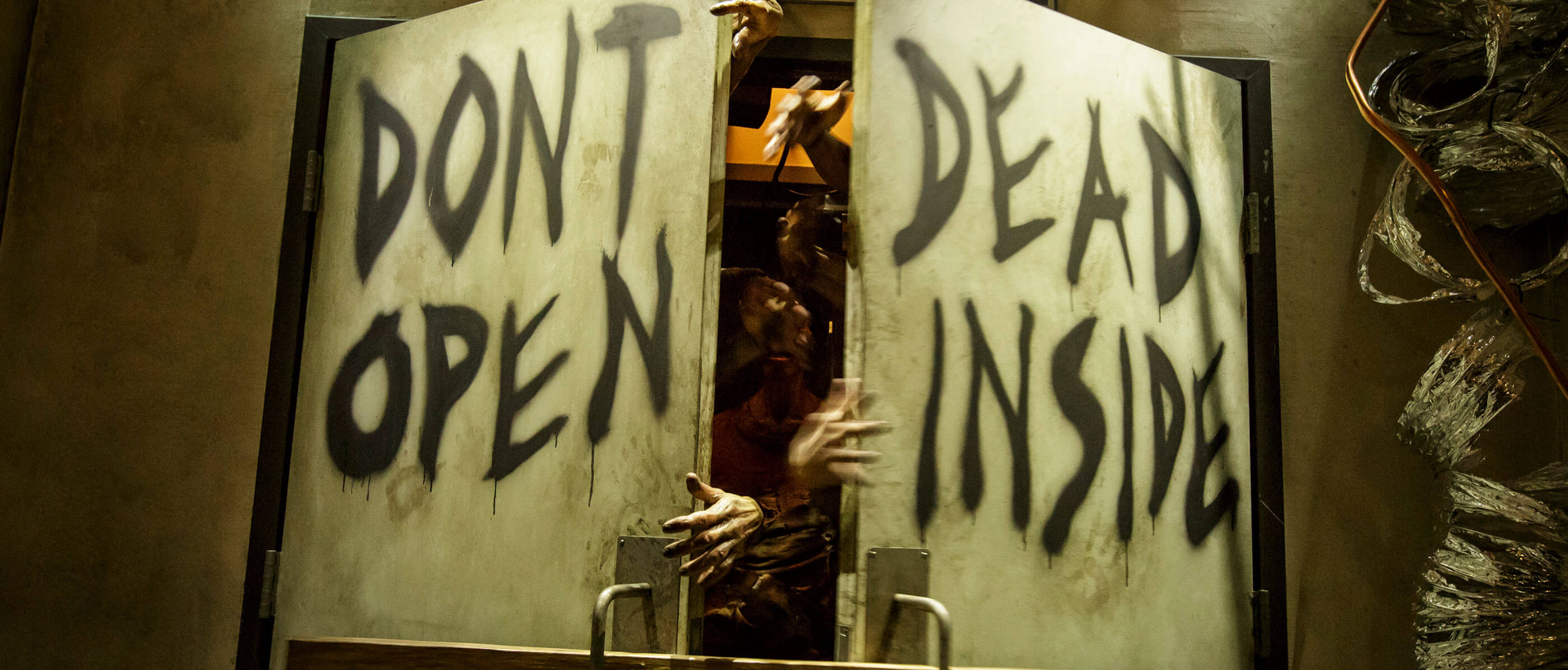 Two doors opening with hands coming out and writing on it saying