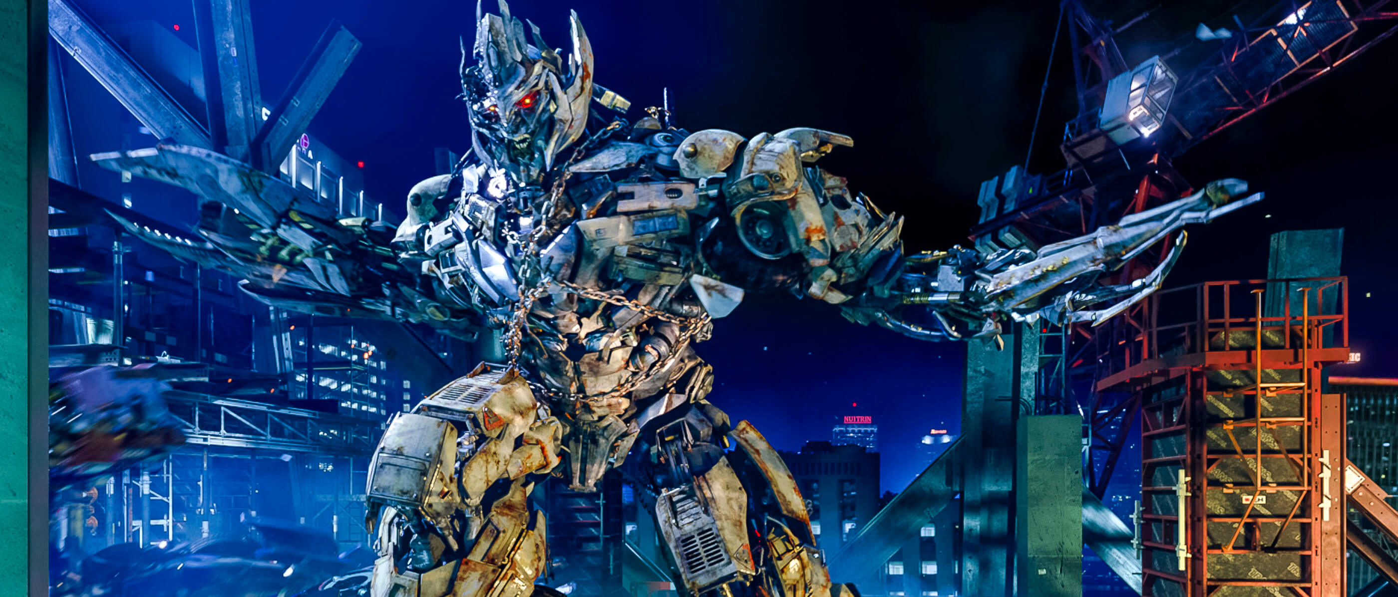 A giant Megatron against a dark blue sky.