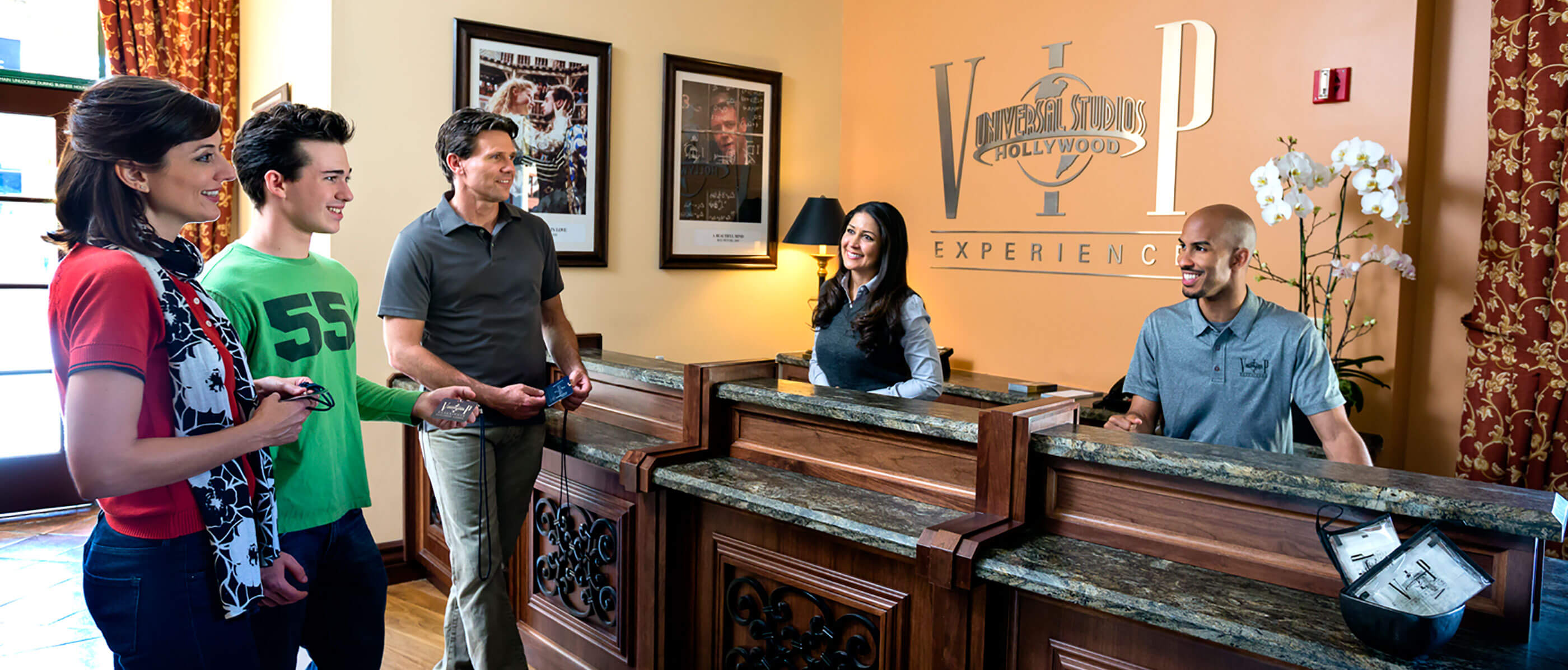 A family at the front desk of Universal Studios Hollywood VIP Experience with two employees.