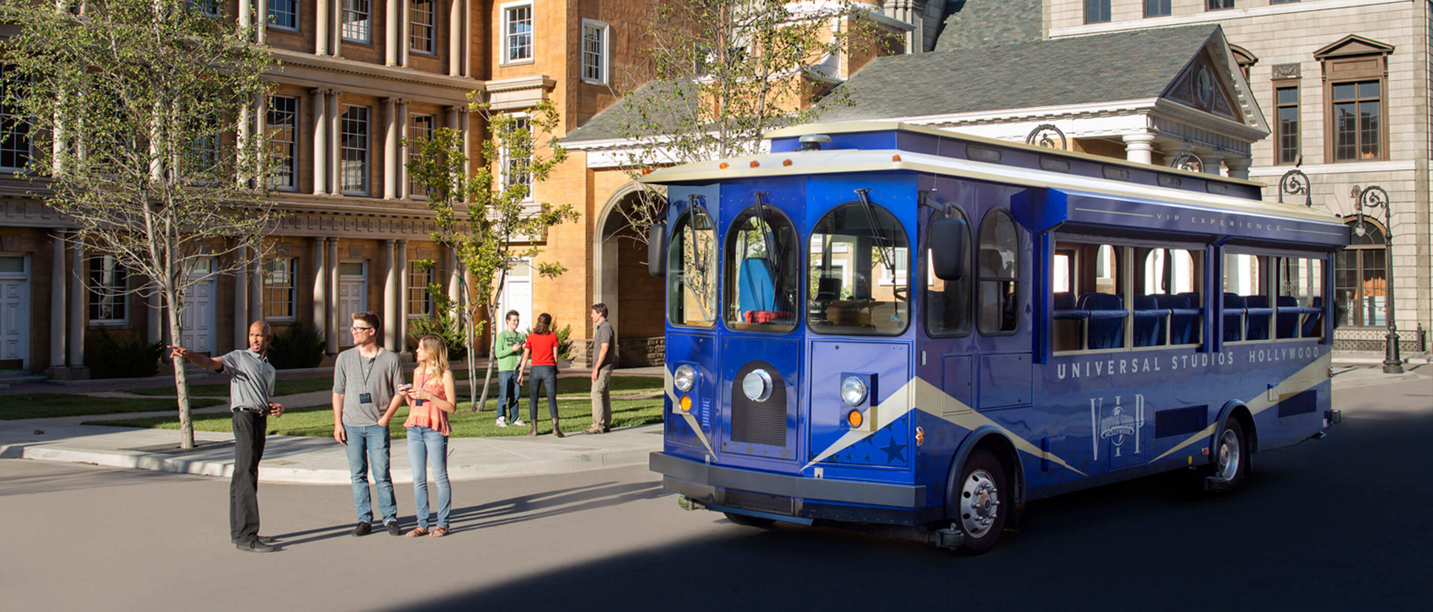 A blue Universal Studios tram and a tour guide giving visitors directions.