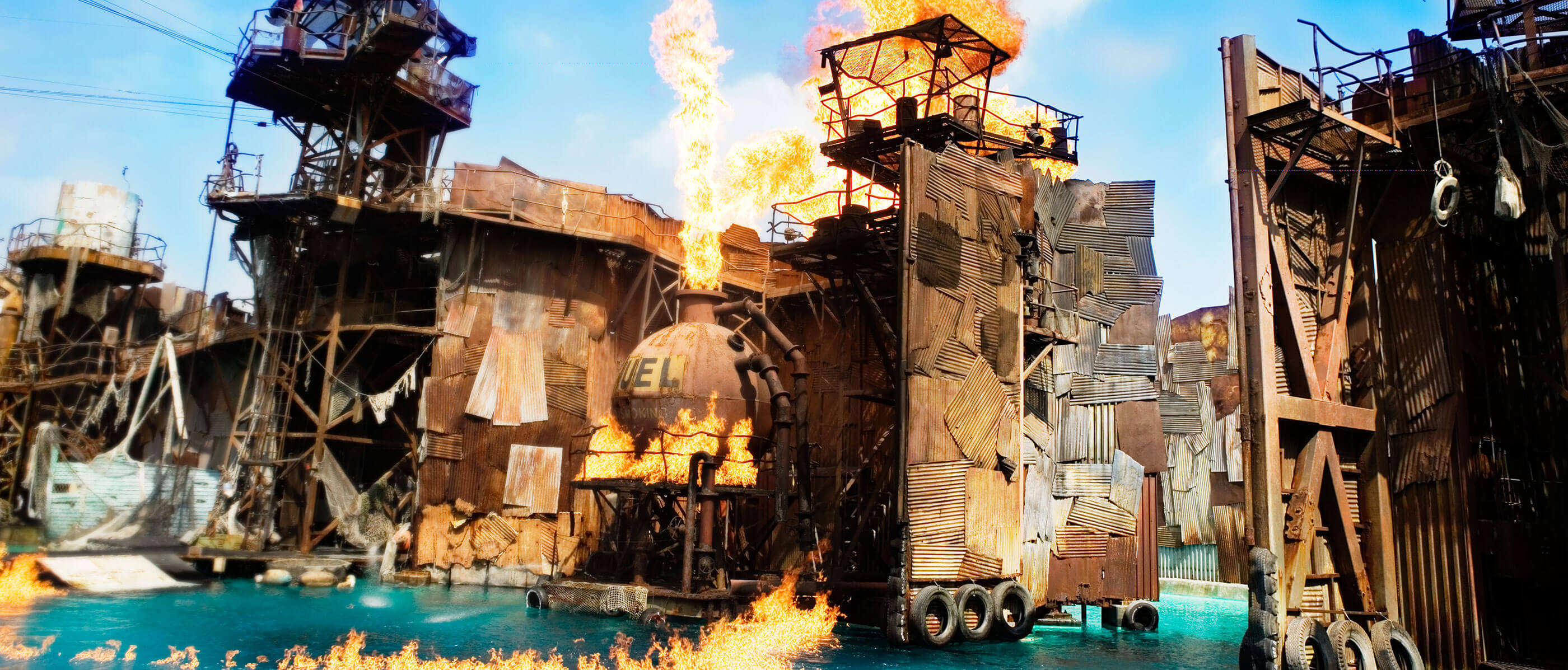 Buildings made of metal sheets on fire above the water.