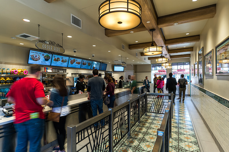 People waiting in line for food at a fast food restaurant.