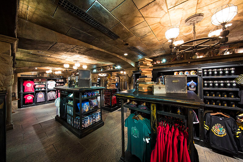 A store with stone pillars and black shelves full of clothes and product.