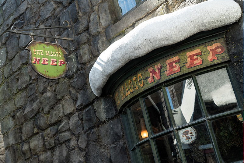 A stone wall with a window and a sign saying The Magic Neep.