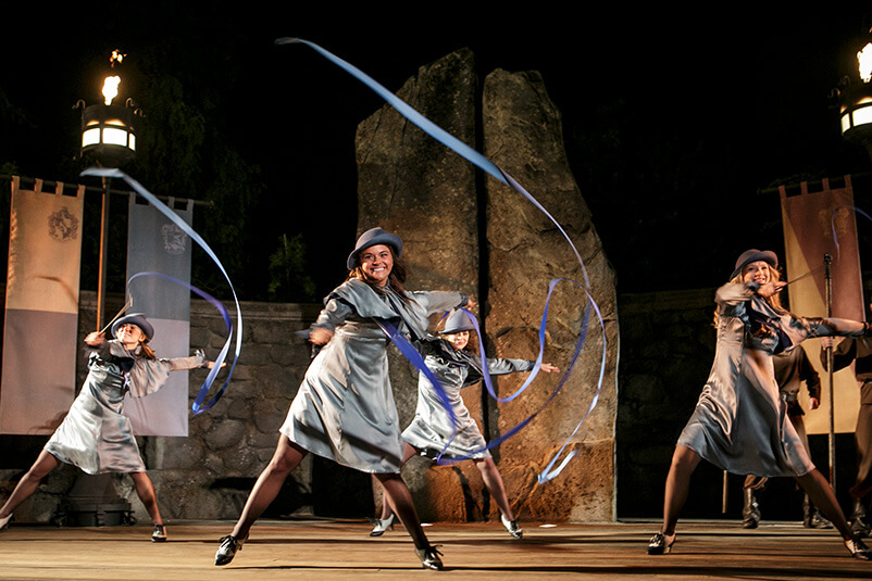 Four women dressed as Harry Potter characters, twirling ribbon.