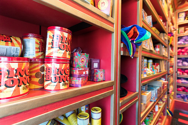 Red shelves with Ping Pong items on them.