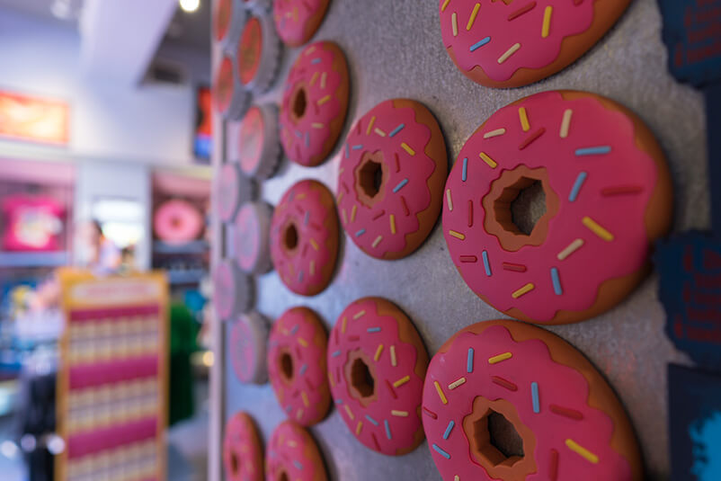 Donuts magnets with pink icing and sprinkles.
