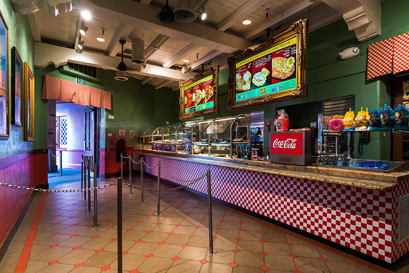 The inside of a fast food restaurant with a red and brown floor.