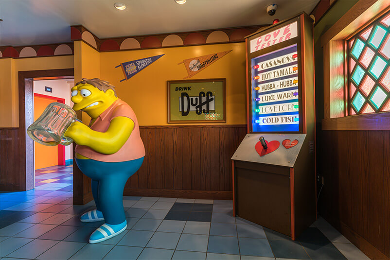A Simpson's character looking into a beer mug at Moe's.