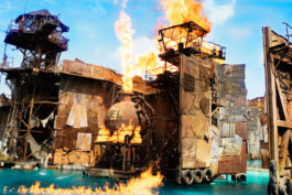 Buildings made of metal sheets on fire above the water.