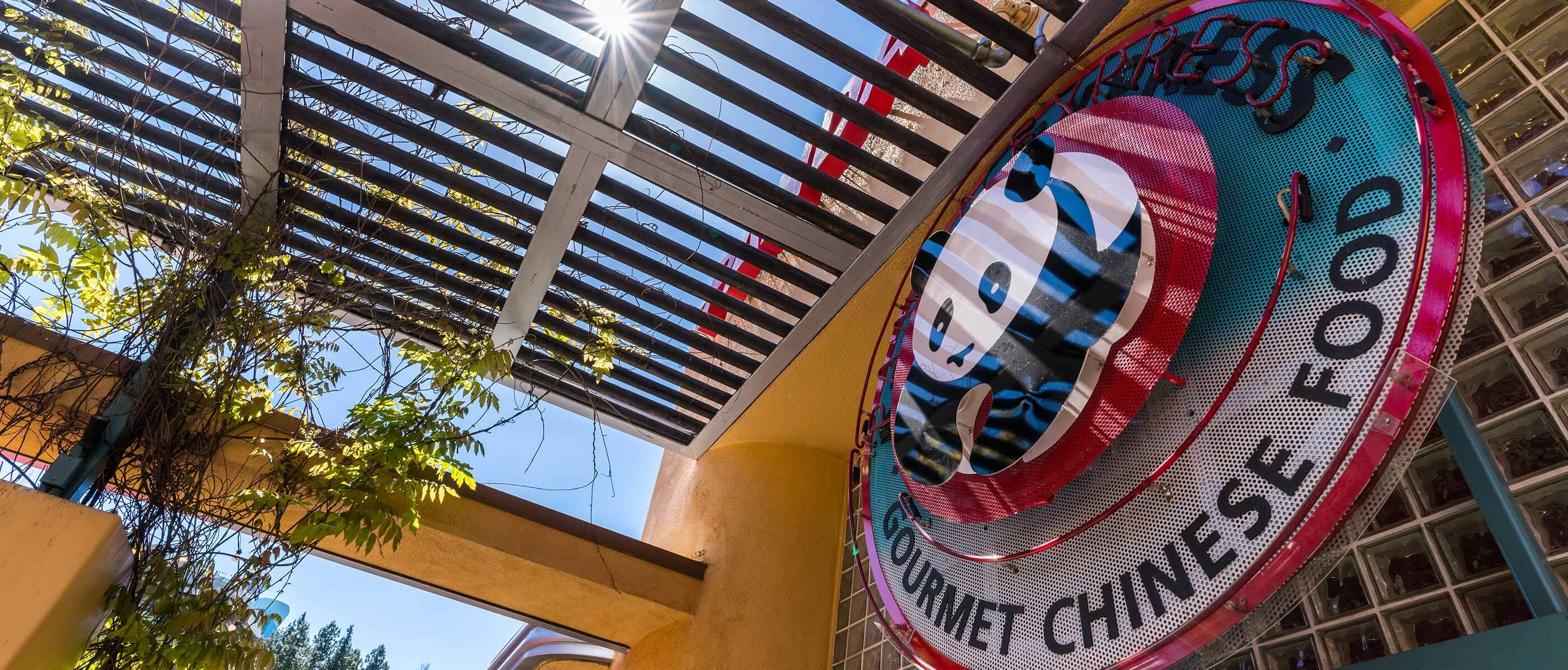A side of a restaurant with a panda on it and Gourmet Chinese Food underneath.