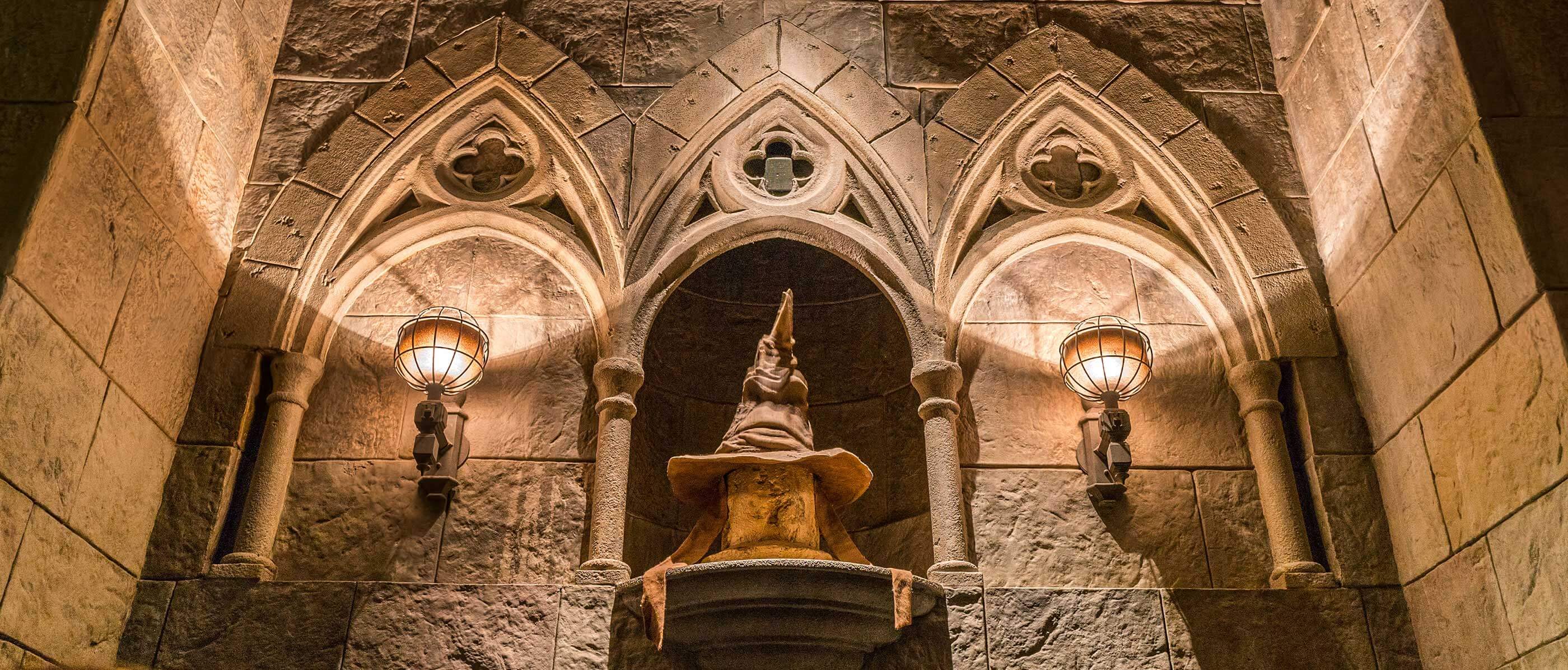 Harry Potter sorting hat with a stone wall and lights behind it.