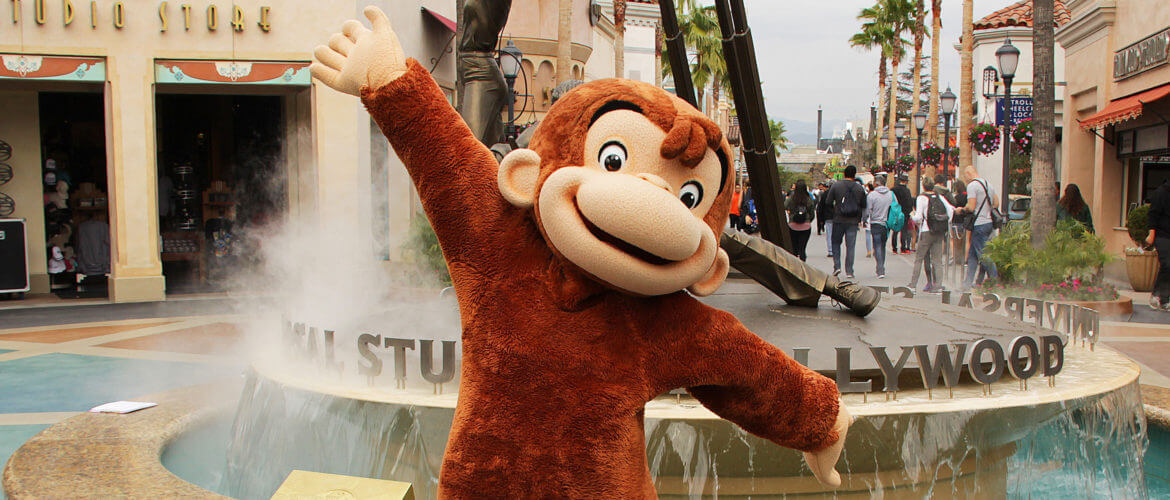 Curious George in front of fountain