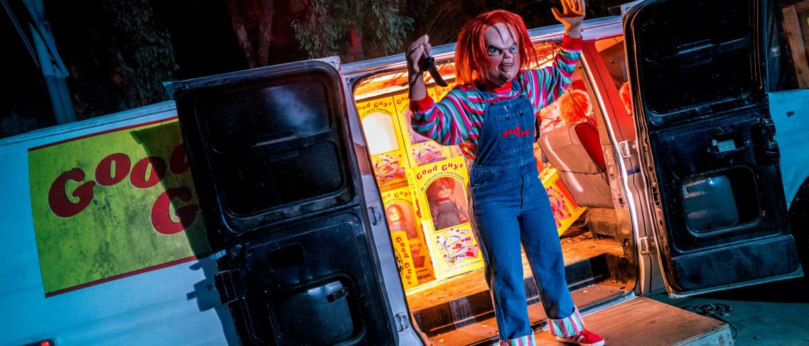 Chucky character standing next to a van
