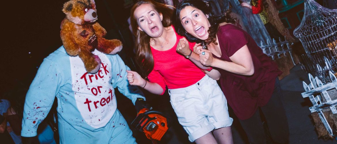 2 girls running away from scary teddy bear with chainsaw