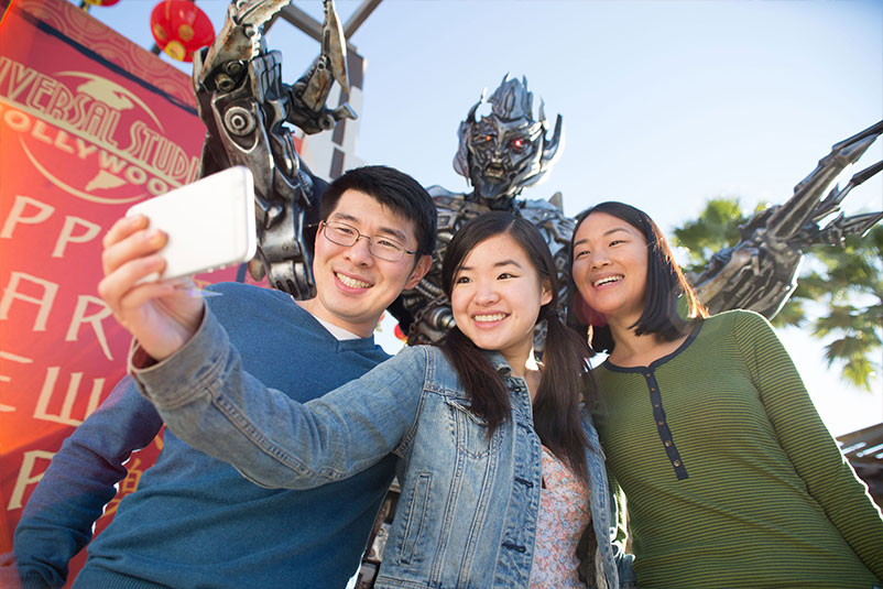 Guests taking a selfie in front of Megatron