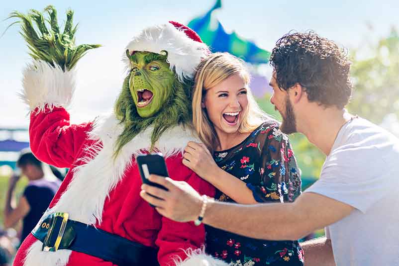 Couple taking pictures with the Grinch